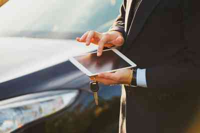 Person bedient Smartphone vor Auto - © kozirsky - stock.adobe.com